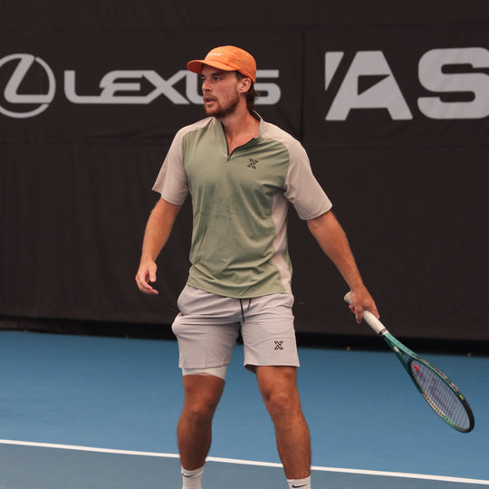 Man on a tennis court holding a racket with a Lexus logo in the background