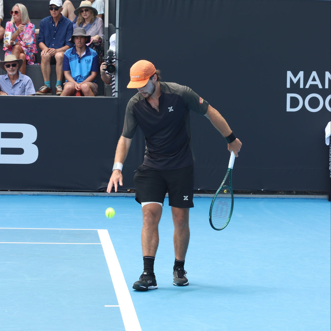 Tennis player on a blue court with spectators in the background